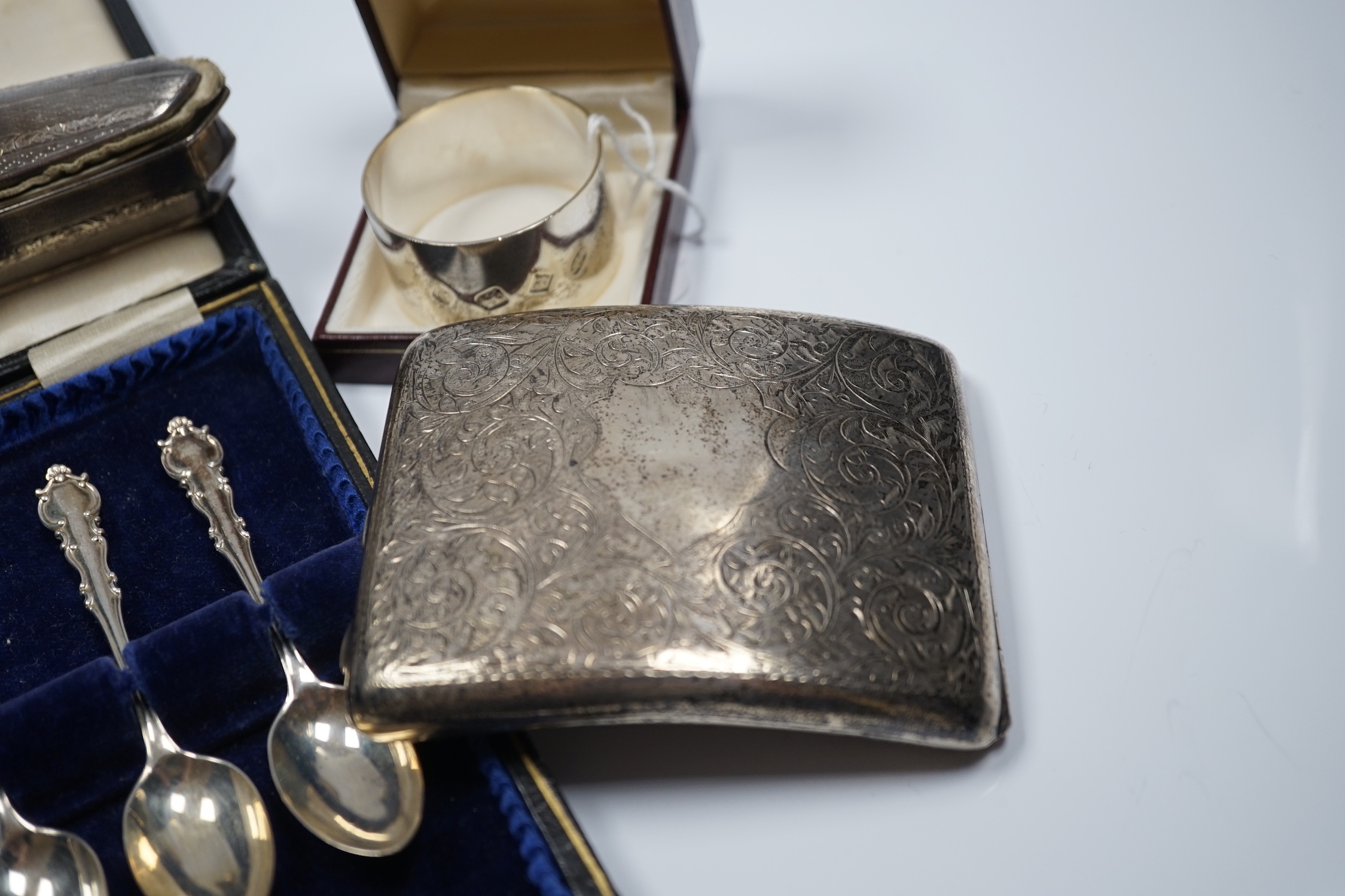 A George V engraved silver mounted nail buffer with cover, Birmingham, 1928, 14.9cm, together with a silver cigarette case, a silver napkin ring and a cased set of six silver teaspoons.